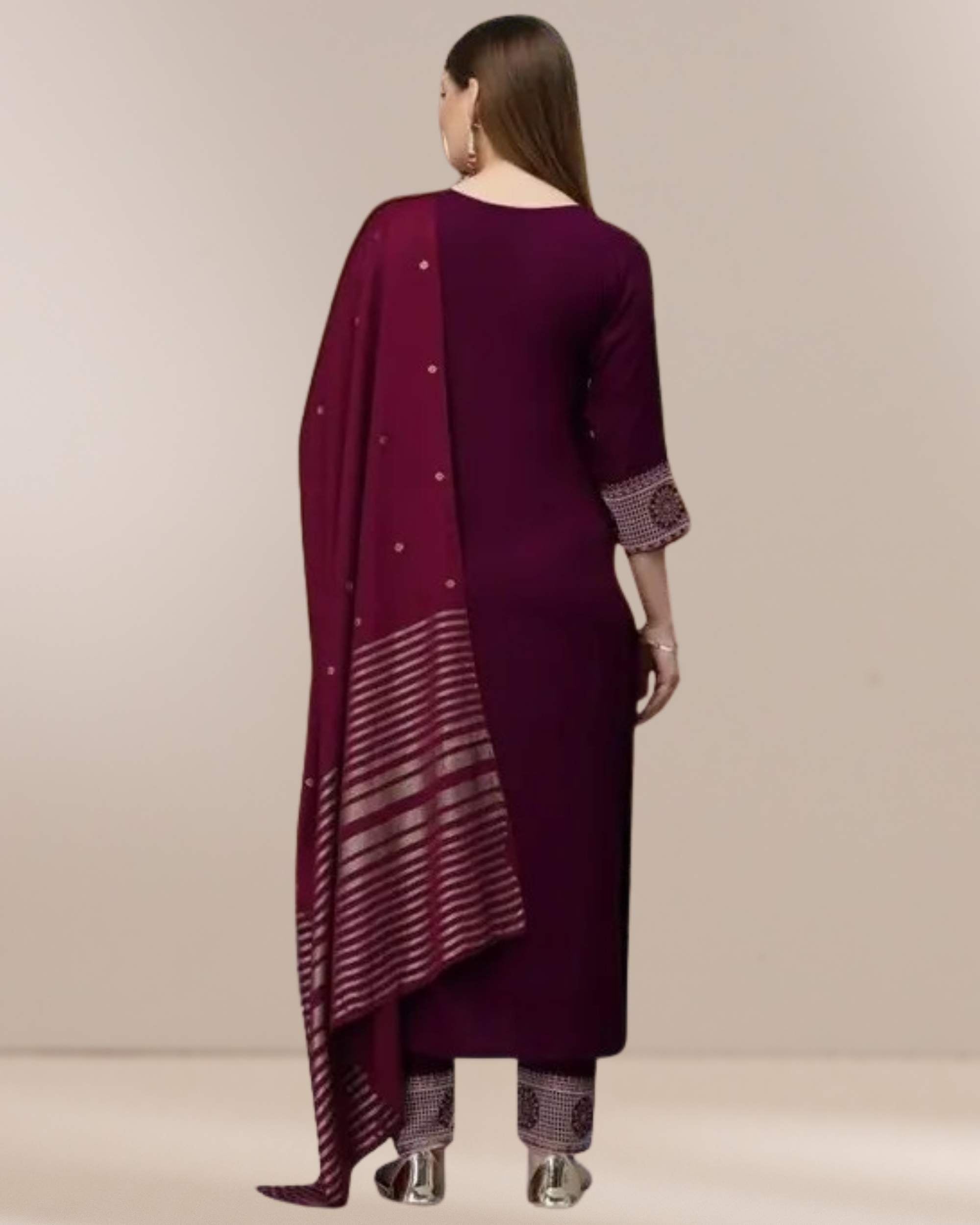Woman wearing a maroon traditional outfit with a matching dupatta on a beige background