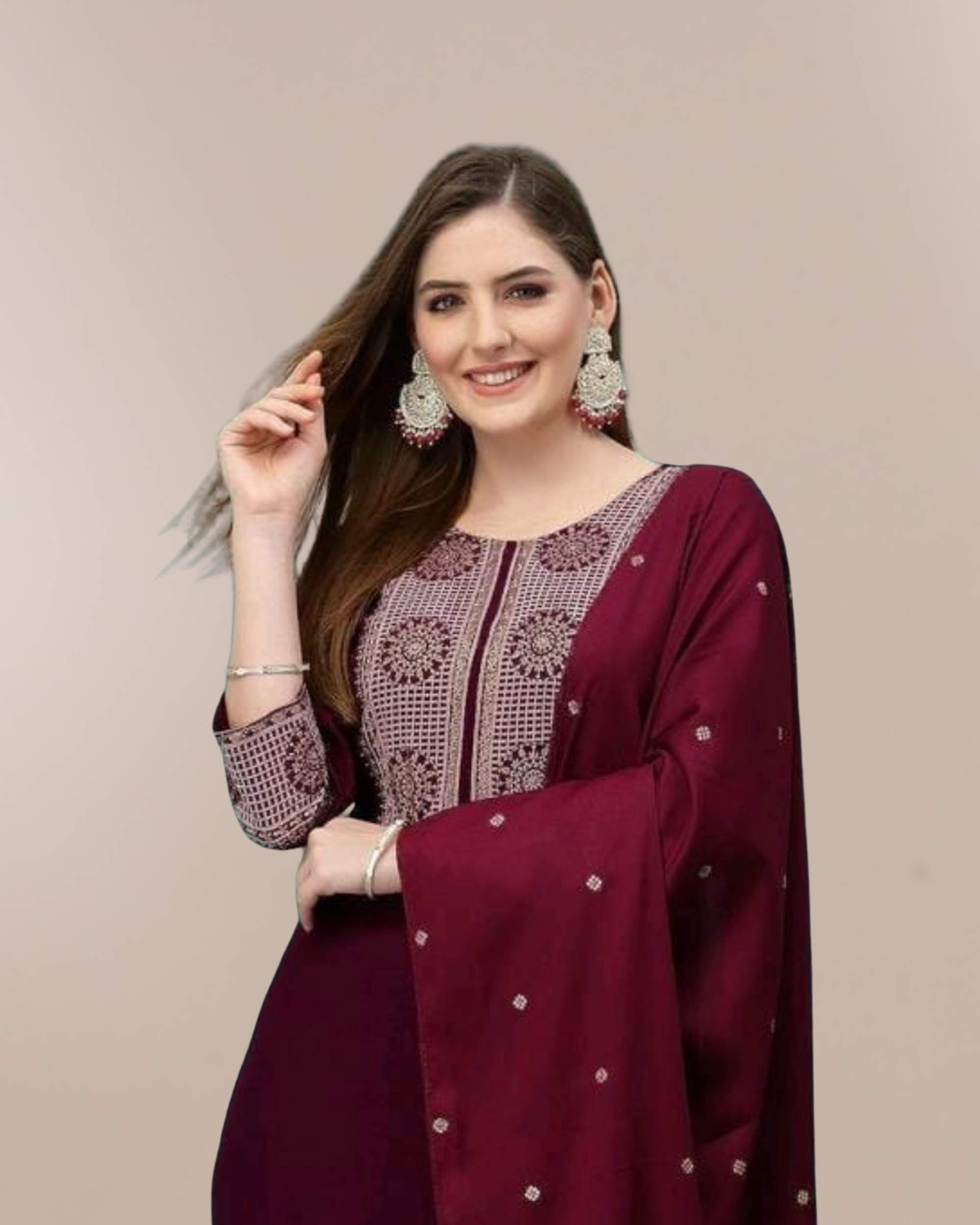 Woman wearing a maroon traditional outfit with intricate designs on a beige background