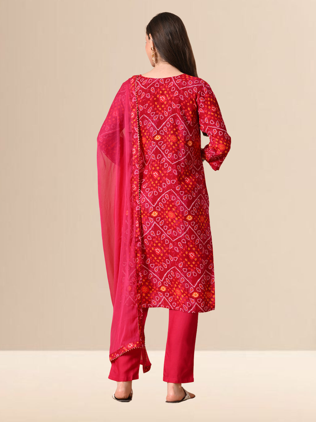 Woman wearing a red Bandhani print cotton kurta set with trousers and a chiffon dupatta, featuring Gota-patti work on the neck, ideal for festive and daily wear.