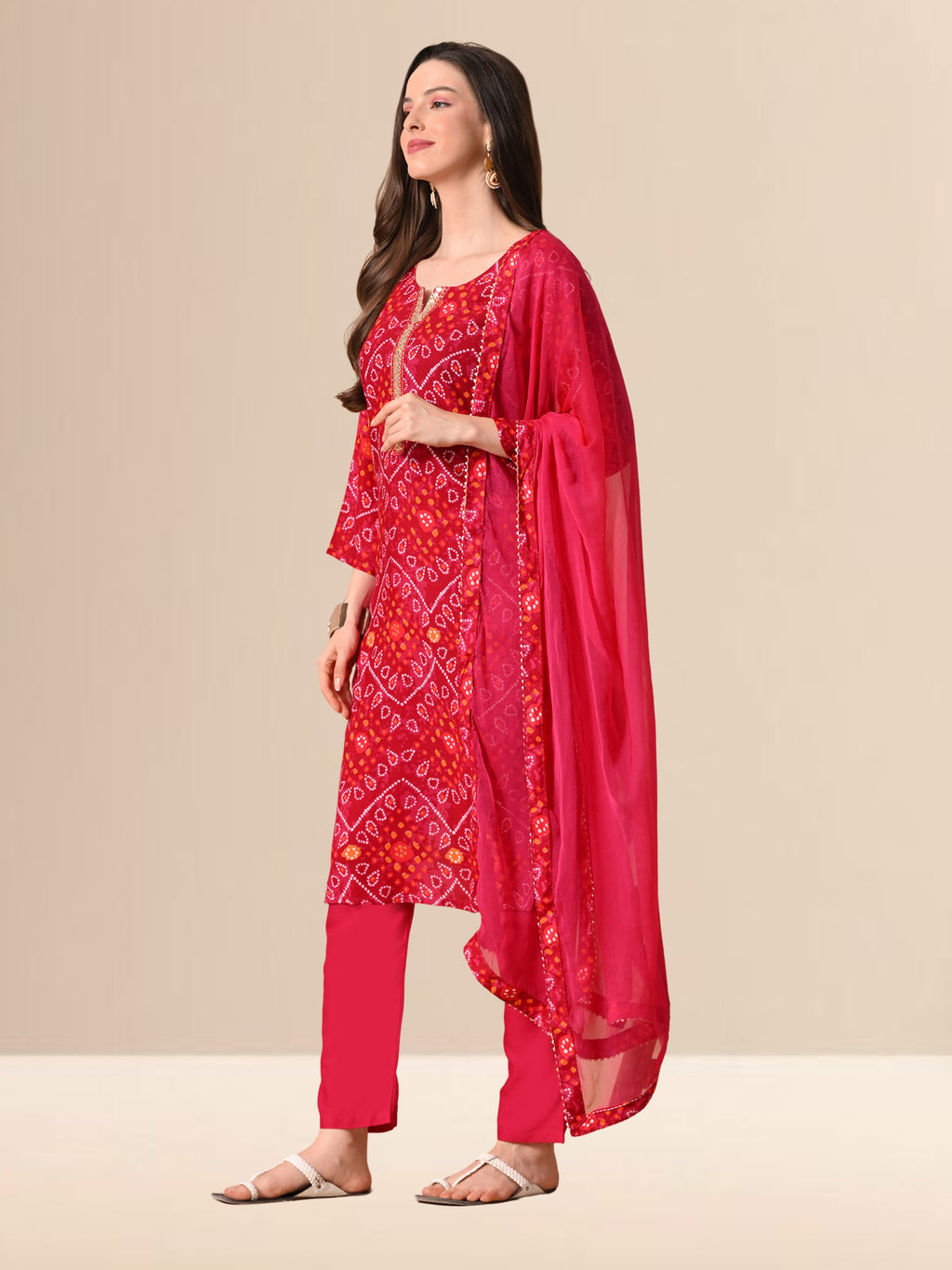 Woman wearing a red Bandhani print cotton kurta set with trousers and a chiffon dupatta, featuring Gota-patti work on the neck, ideal for festive and daily wear.