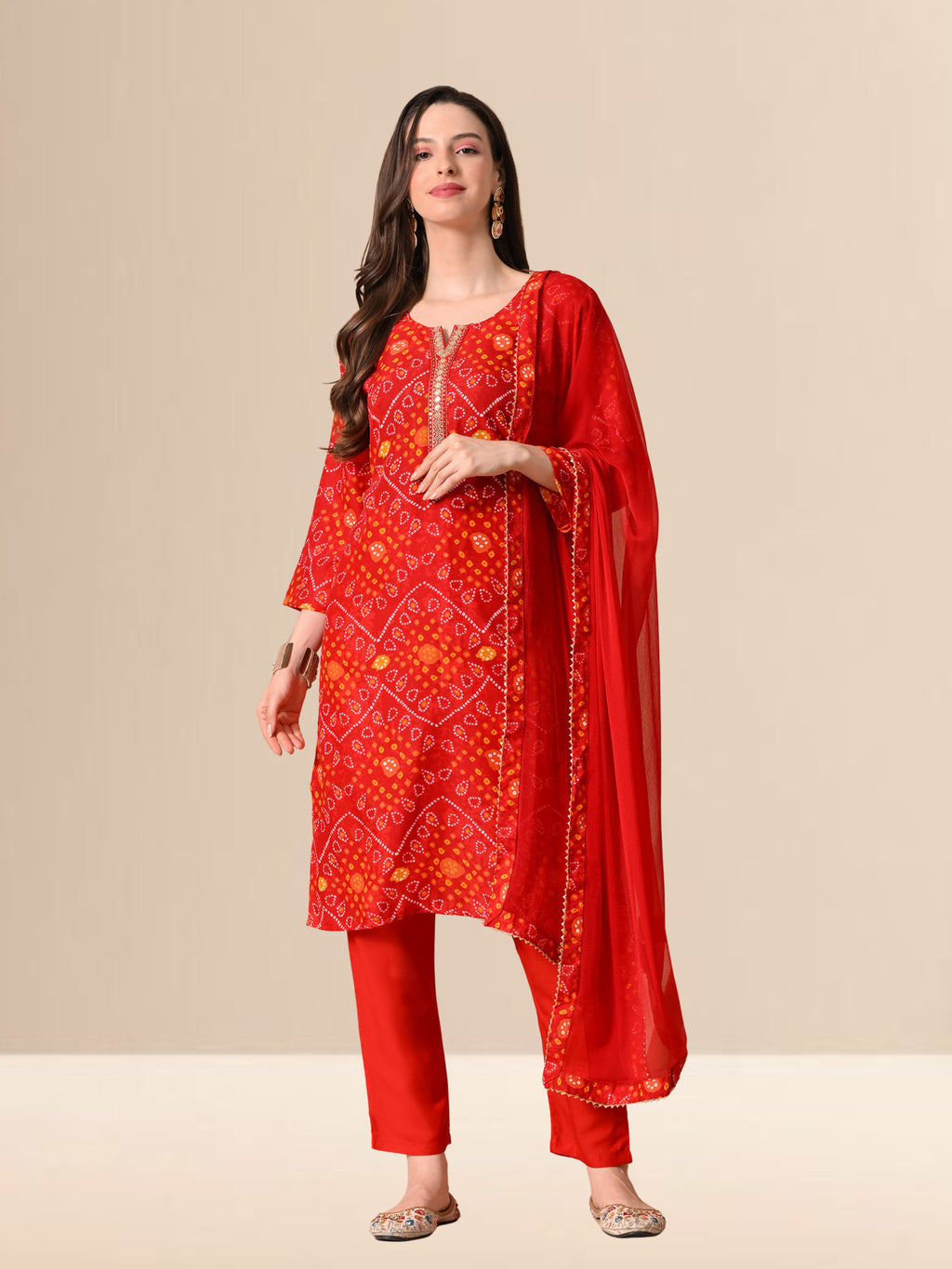 Woman wearing a red traditional outfit with a matching dupatta on a beige background
