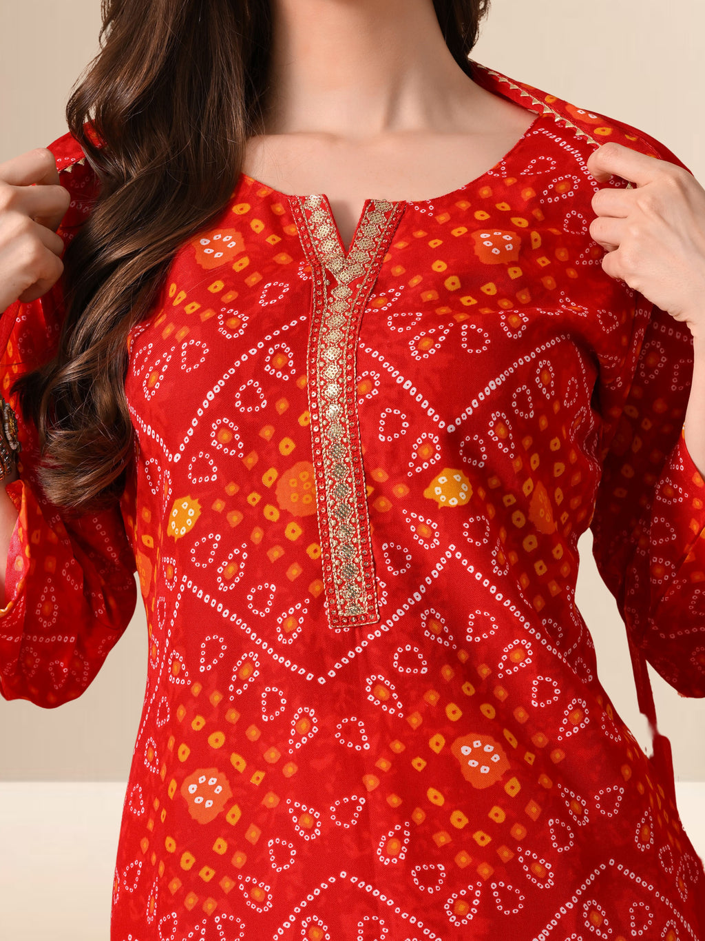 Red embroidered traditional outfit with intricate patterns on a neutral background