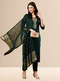 A woman wearing a deep emerald green straight-cut kurta with golden neck embroidery, black trousers, and a dark green Banarasi art silk dupatta with gold patterns.