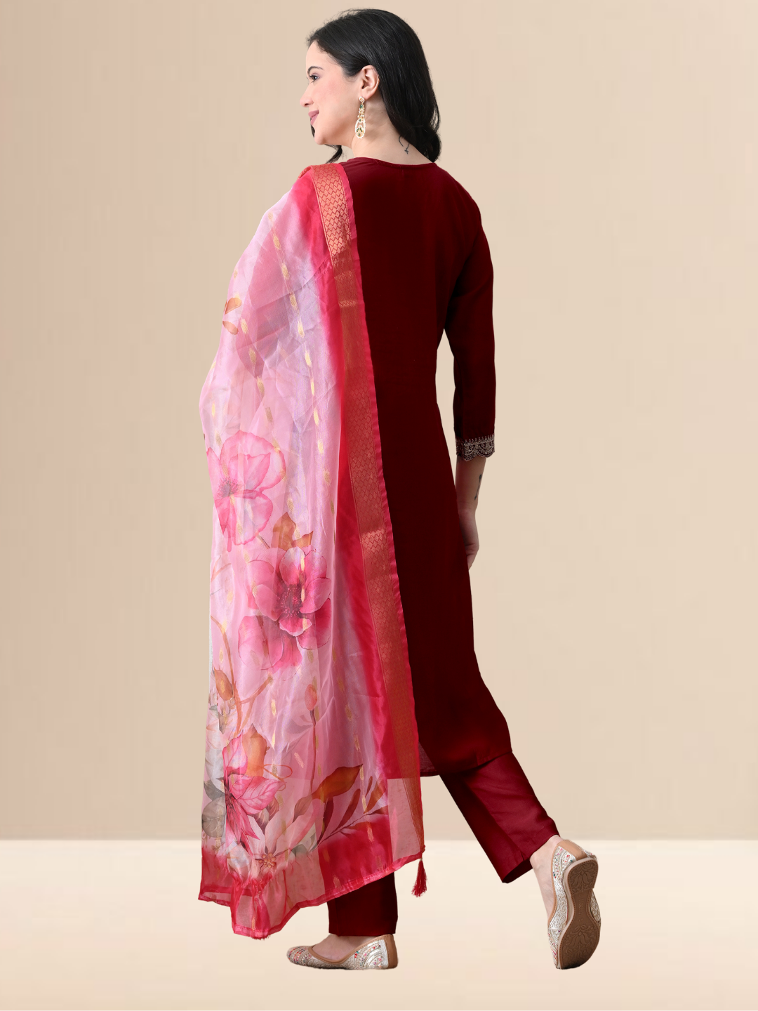 A woman wearing a maroon straight-cut cotton blend kurta with ivory yoke embroidery, matching pants, and a pink floral dupatta.
