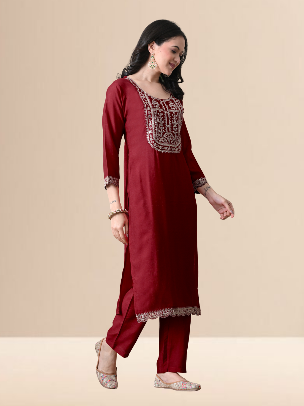 A woman wearing a maroon straight-cut cotton blend kurta with ivory yoke embroidery, matching pants, and a pink floral dupatta.
