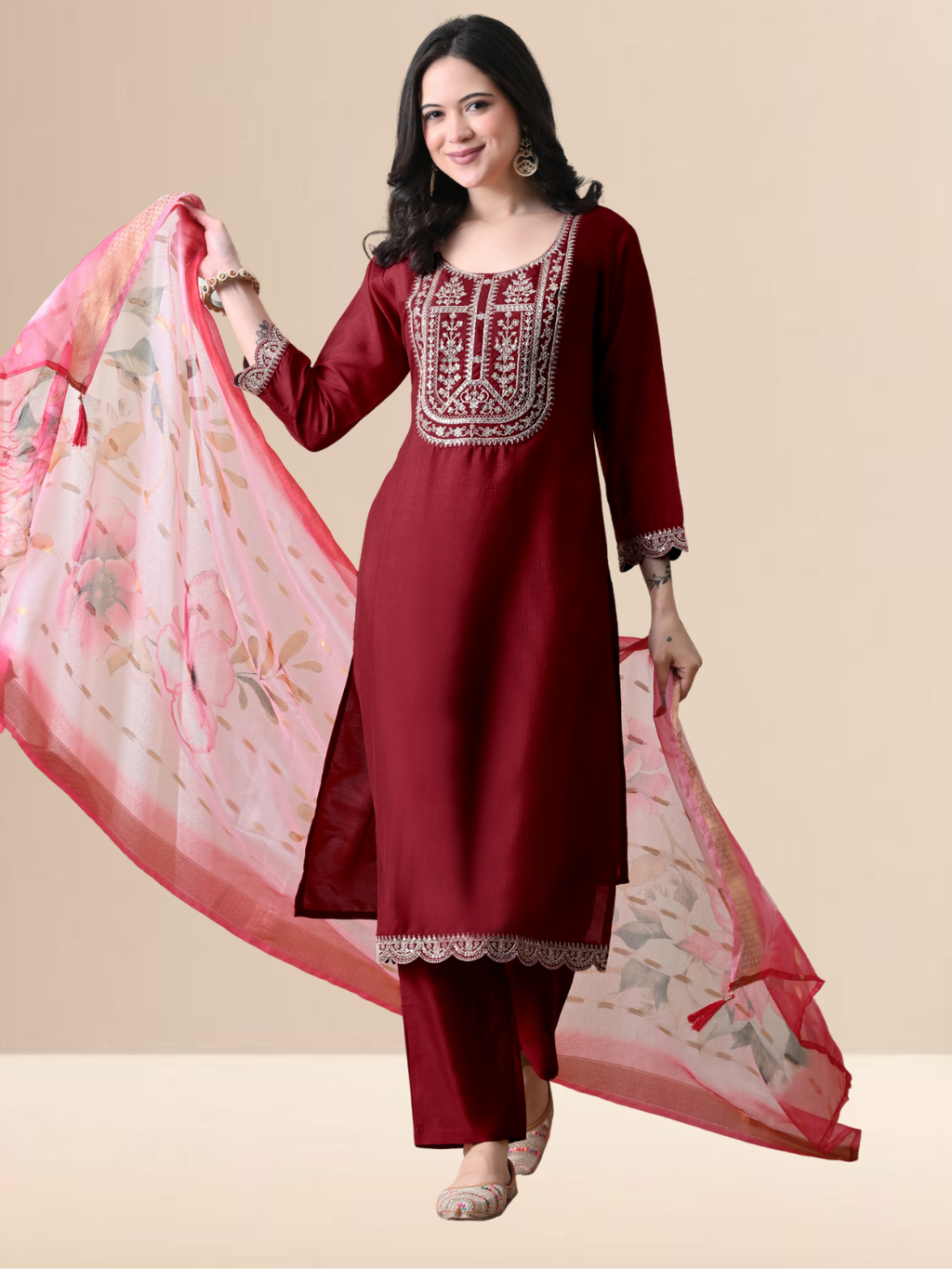 A woman wearing a maroon straight-cut cotton blend kurta with ivory yoke embroidery, matching pants, and a pink floral dupatta.