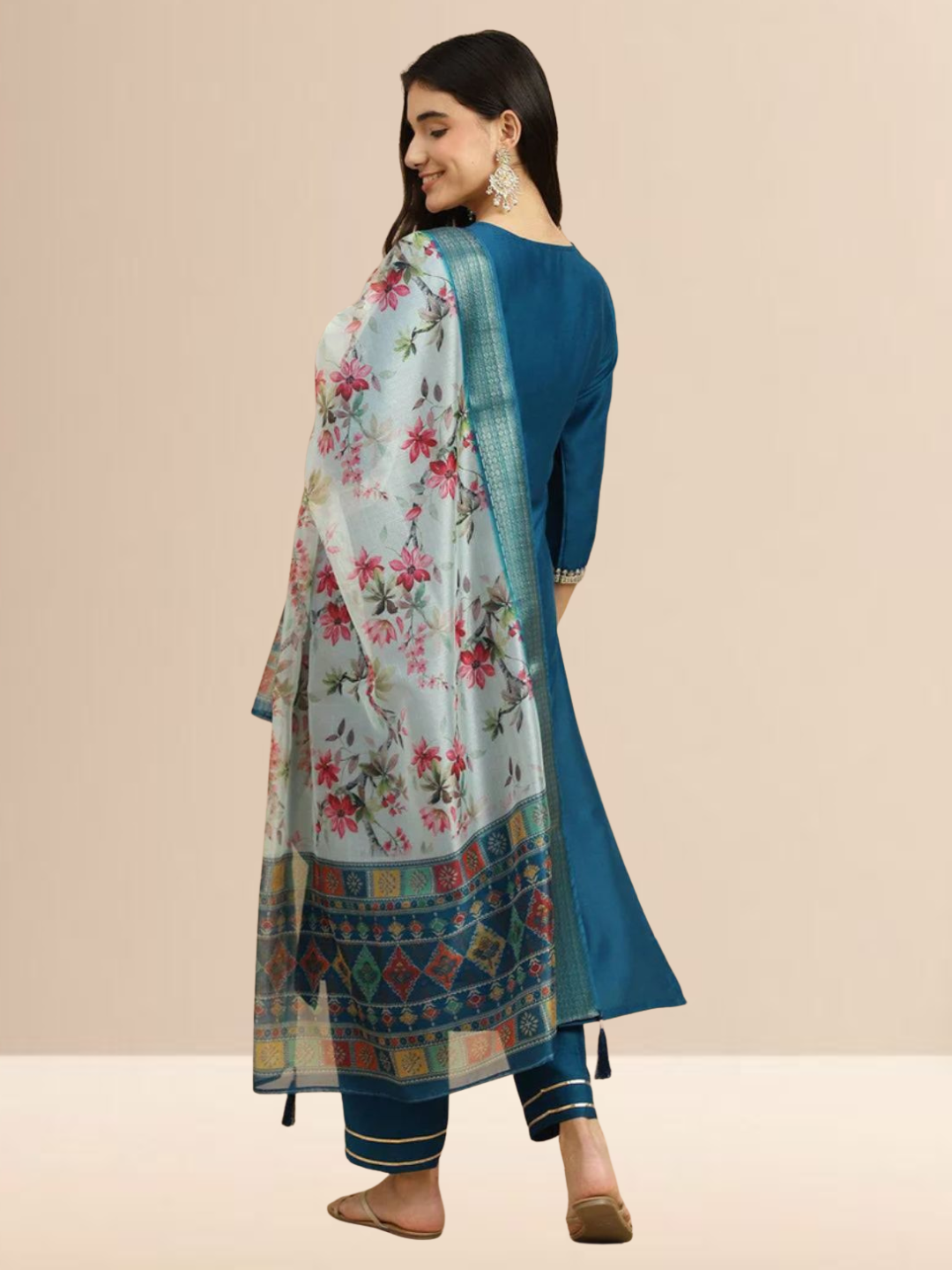 Woman wearing a teal blue Cotton blend kurta with silver embroidery on the neck, matching pants, and a white floral printed dupatta.