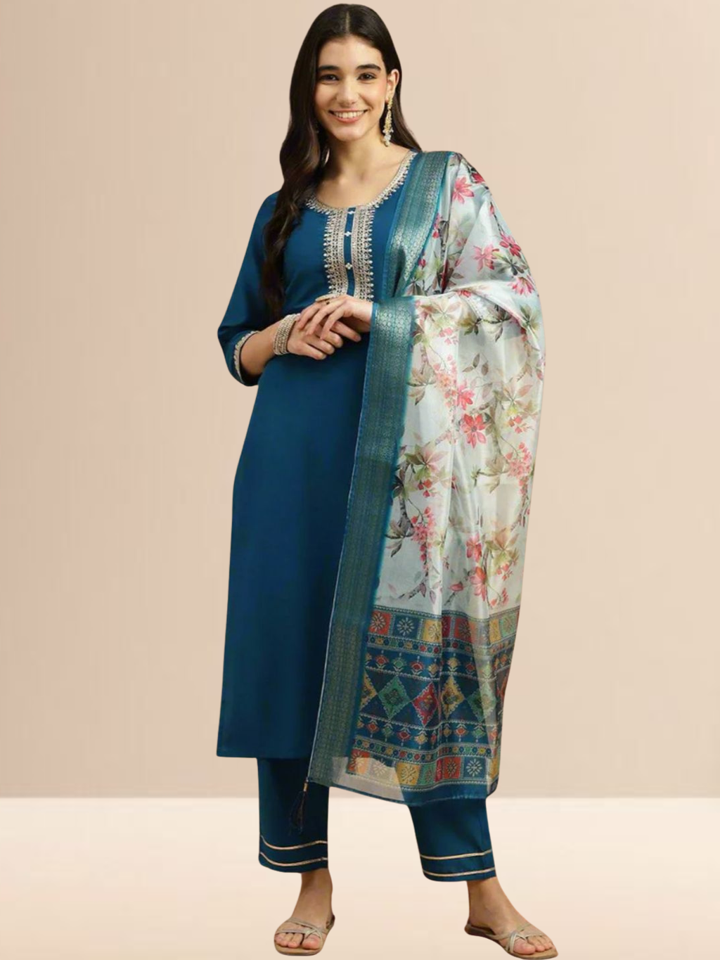 Woman wearing a teal blue Cotton blend kurta with silver embroidery on the neck, matching pants, and a white floral printed dupatta.