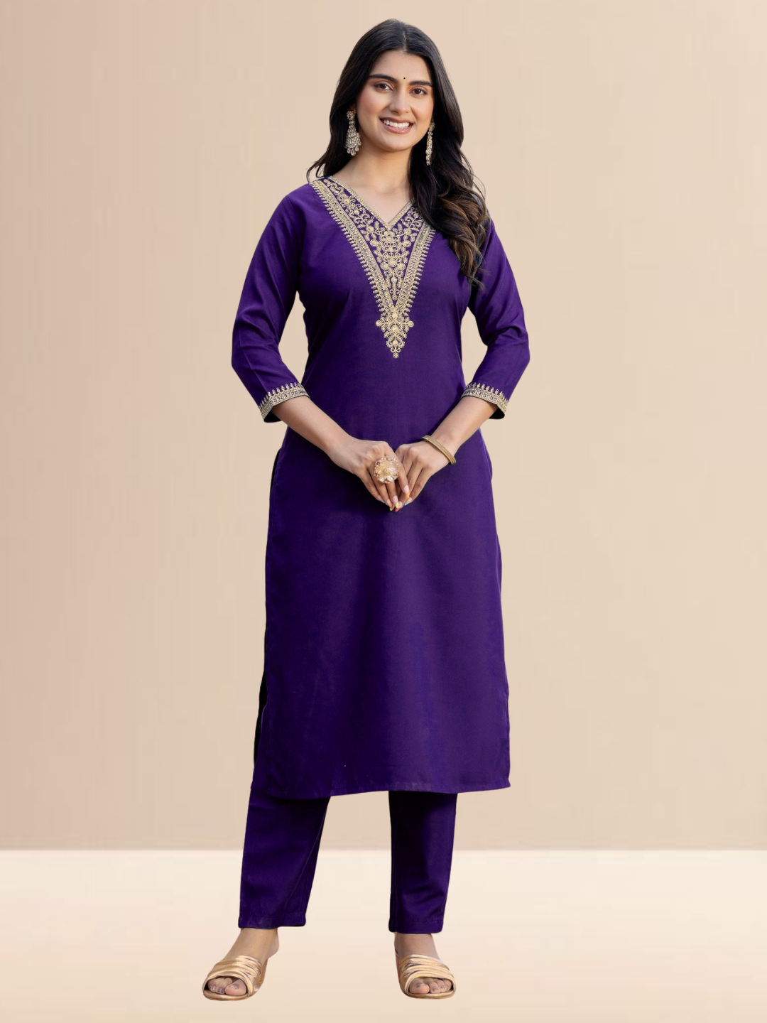 Woman wearing a purple traditional outfit with intricate embroidery on a beige background