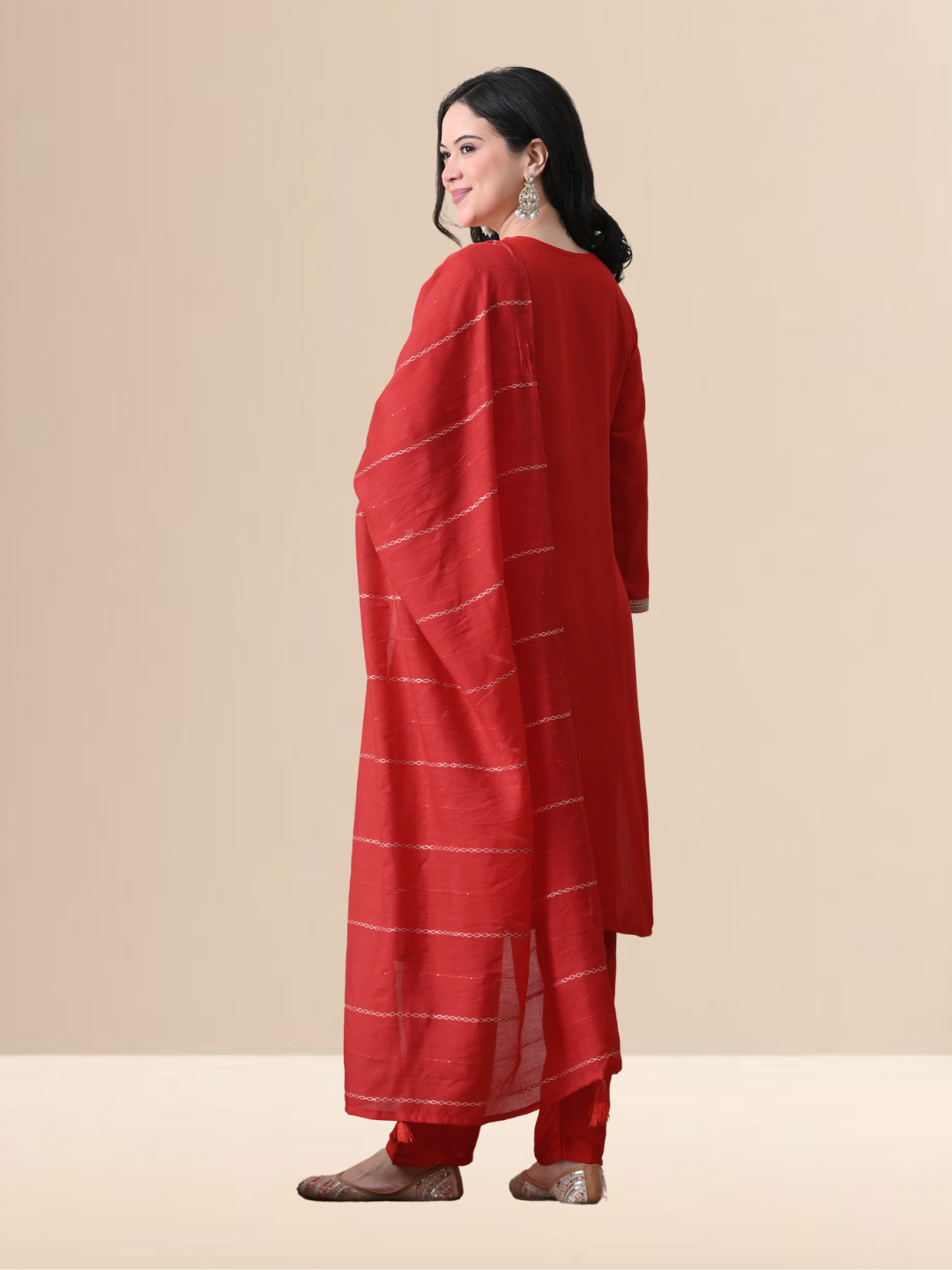 A woman wearing a red straight-cut cotton blend kurta with V-neck embroidery, matching trousers, and a red dupatta.