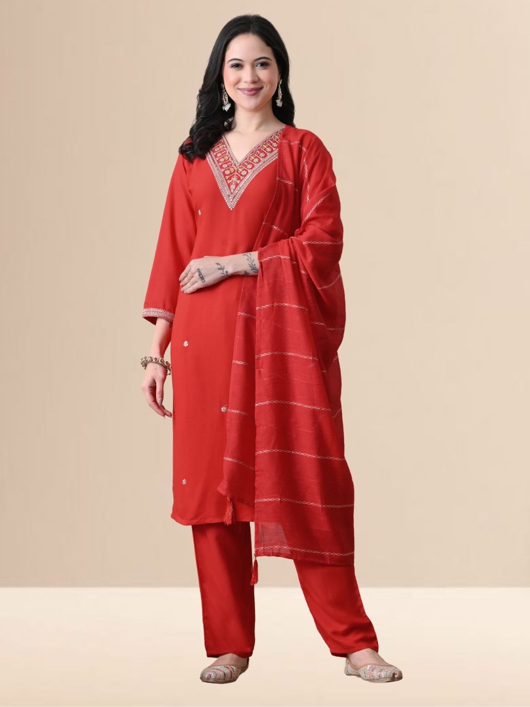 A woman wearing a red straight-cut cotton blend kurta with V-neck embroidery, matching trousers, and a red dupatta.