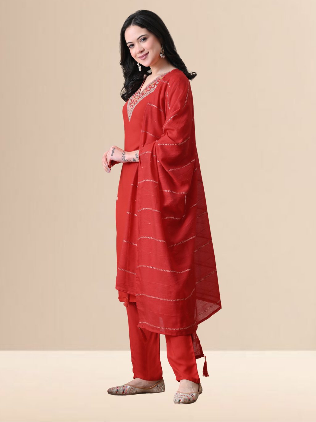 A woman wearing a red straight-cut cotton blend kurta with V-neck embroidery, matching trousers, and a red dupatta.