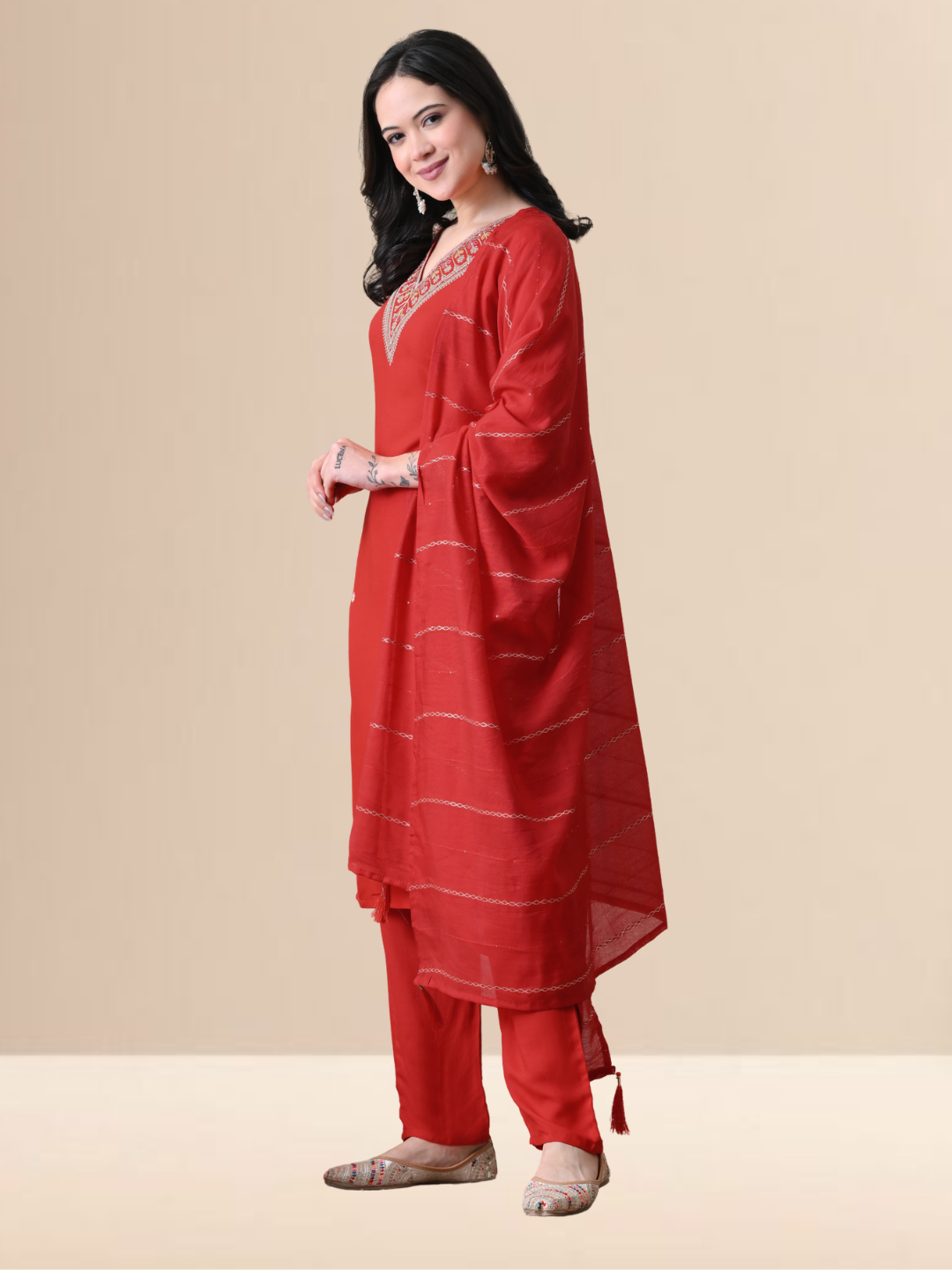 A woman wearing a red straight-cut cotton blend kurta with V-neck embroidery, matching trousers, and a red dupatta.