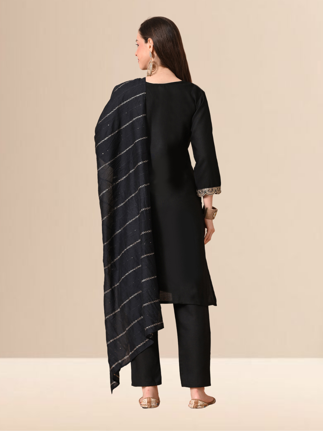 Woman wearing a black straight-cut cotton blend kurta with gold V-neck embroidery, matching trousers, and a black dupatta with gold stripes.