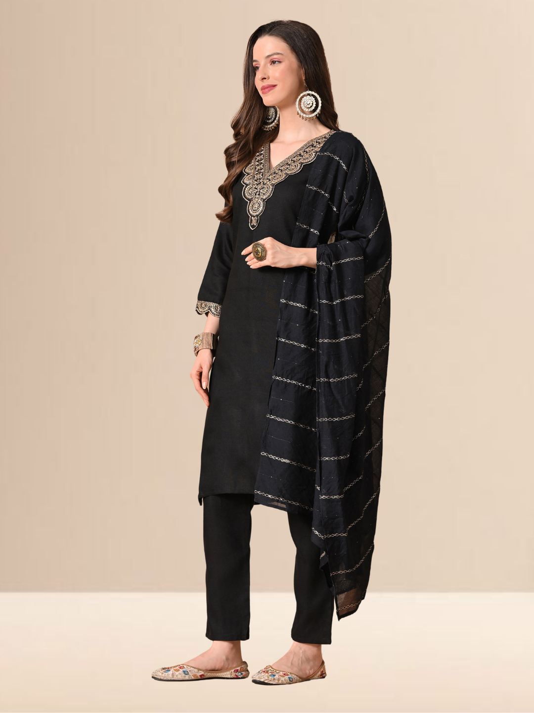 Woman wearing a black straight-cut cotton blend kurta with gold V-neck embroidery, matching trousers, and a black dupatta with gold stripes.