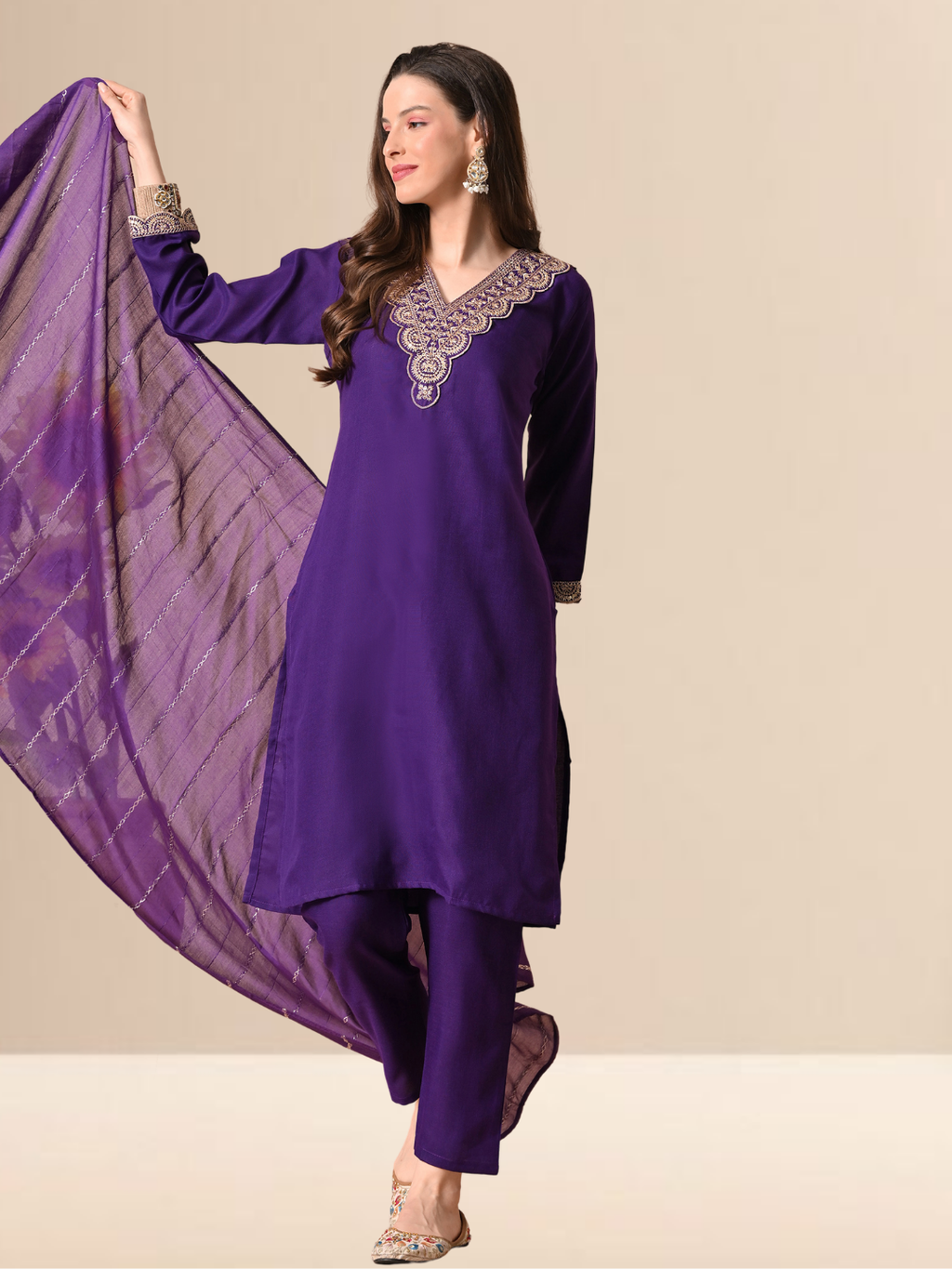A woman wearing a royal purple straight-cut cotton blend kurta with gold V-neck embroidery, matching trousers, and a purple patterned dupatta.