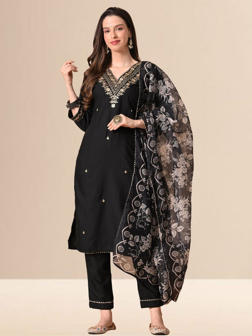 A woman wearing a black cotton blend kurta set with golden embroidery on the neck and a floral printed dupatta.