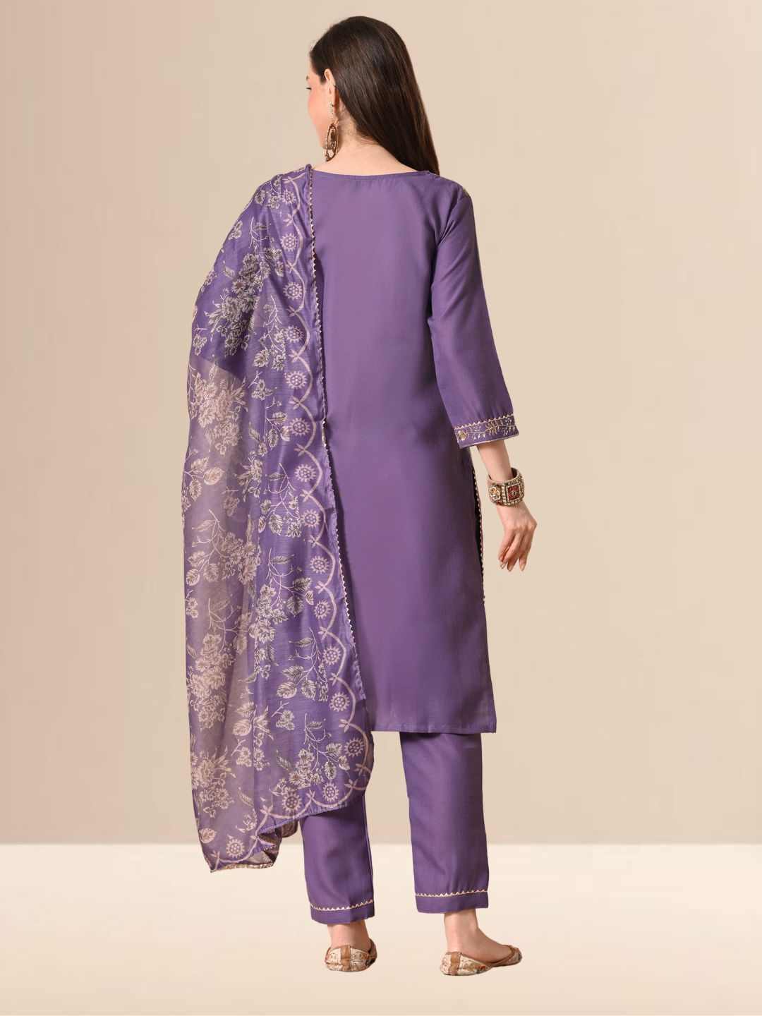 A woman wearing a mauve cotton blend kurta set with golden embroidery on the neck and a floral dupatta.