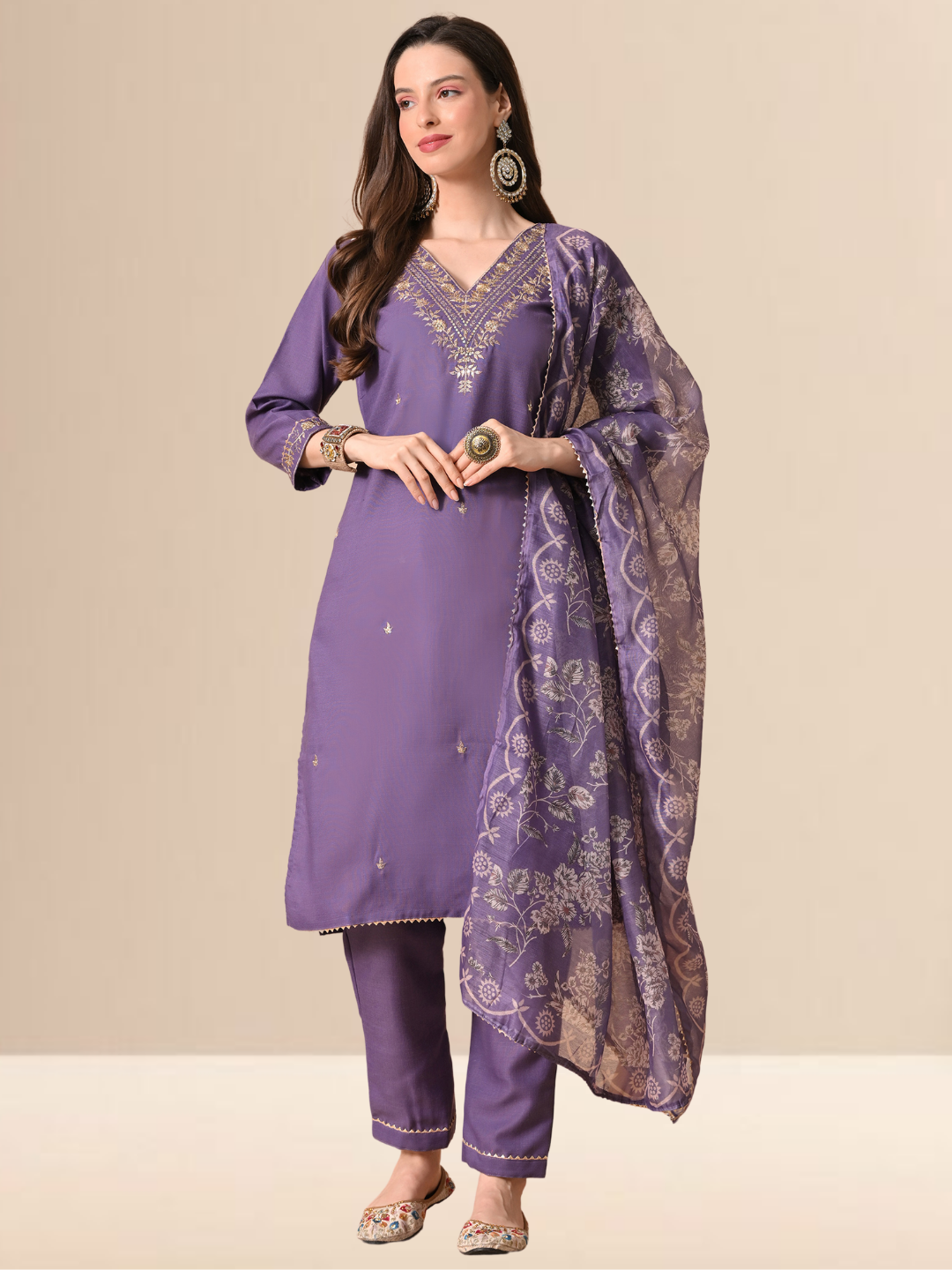 A woman wearing a mauve cotton blend kurta set with golden embroidery on the neck and a floral dupatta.