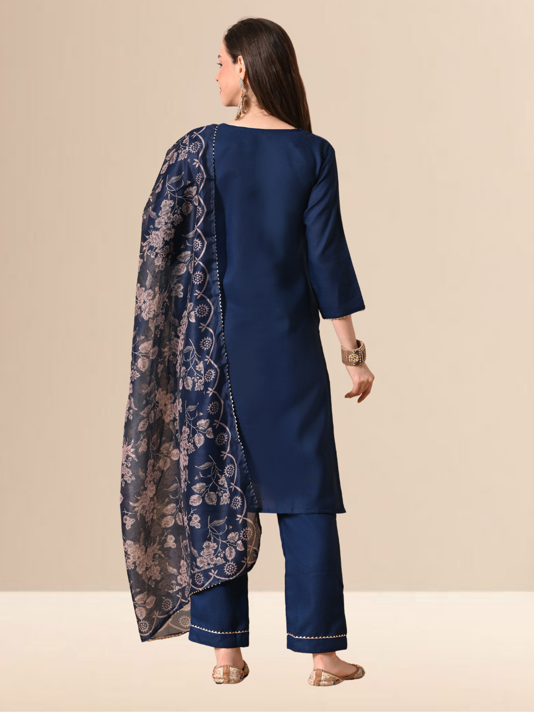 Woman wearing a navy blue cotton blend kurta set with golden V-neck embroidery and a floral printed dupatta.