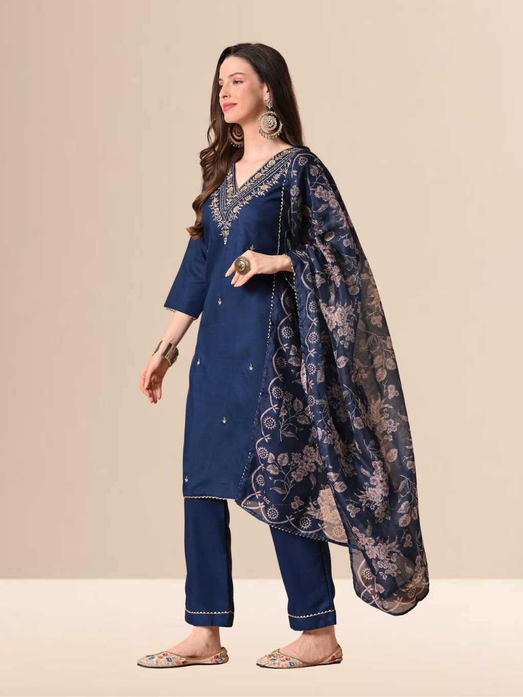 Woman wearing a navy blue cotton blend kurta set with golden V-neck embroidery and a floral printed dupatta.