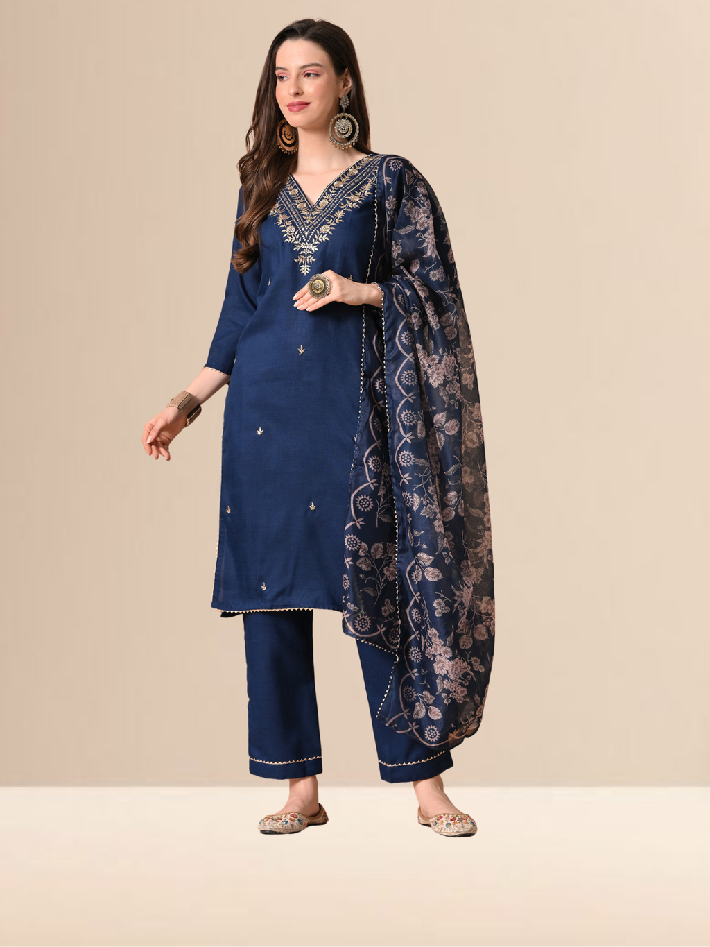 Woman wearing a navy blue cotton blend kurta set with golden V-neck embroidery and a floral printed dupatta.