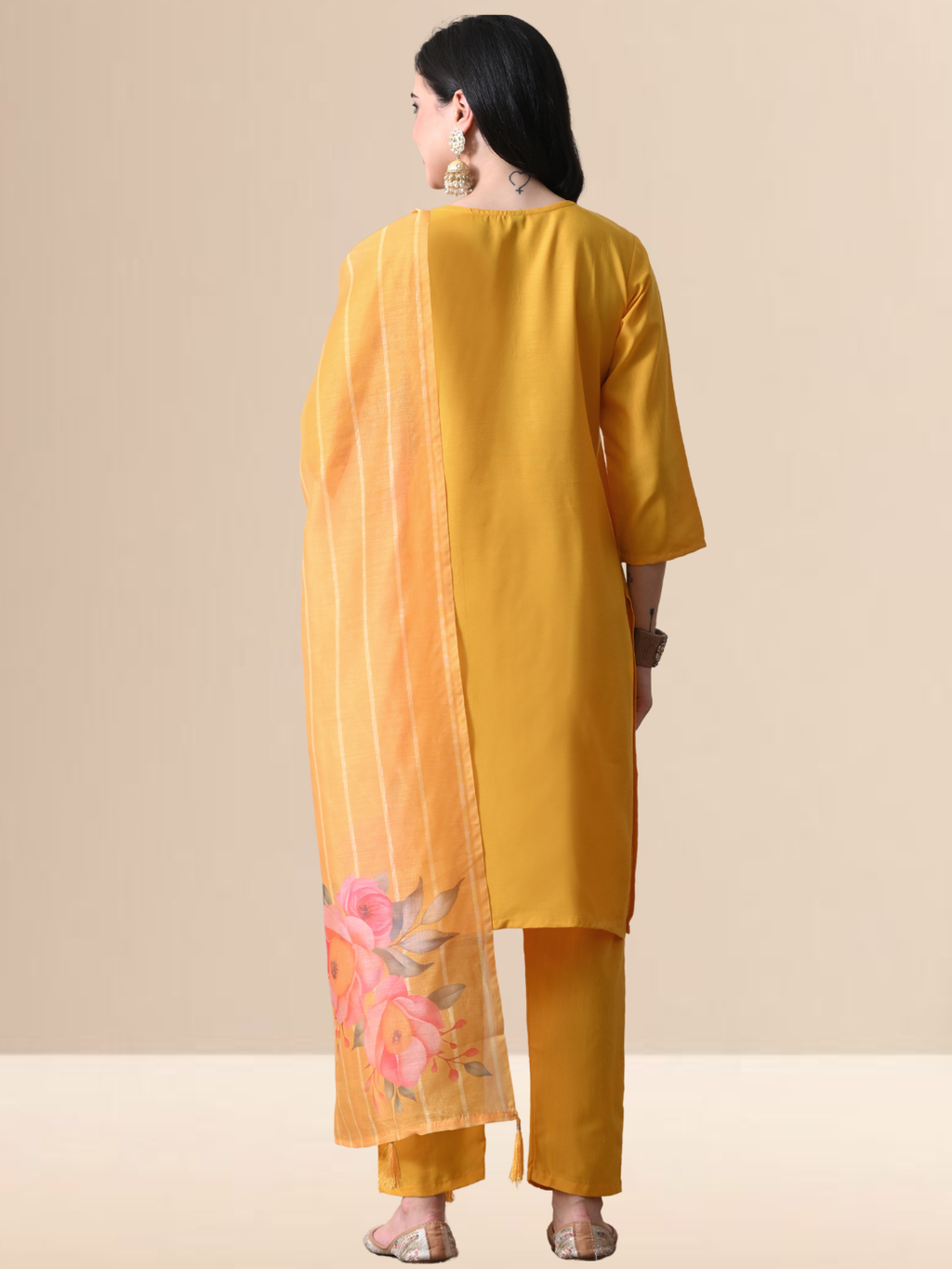Woman wearing a mustard yellow Cotton blend kurta with multicolored floral embroidery on the neck, matching pants, and an orange floral printed dupatta.
