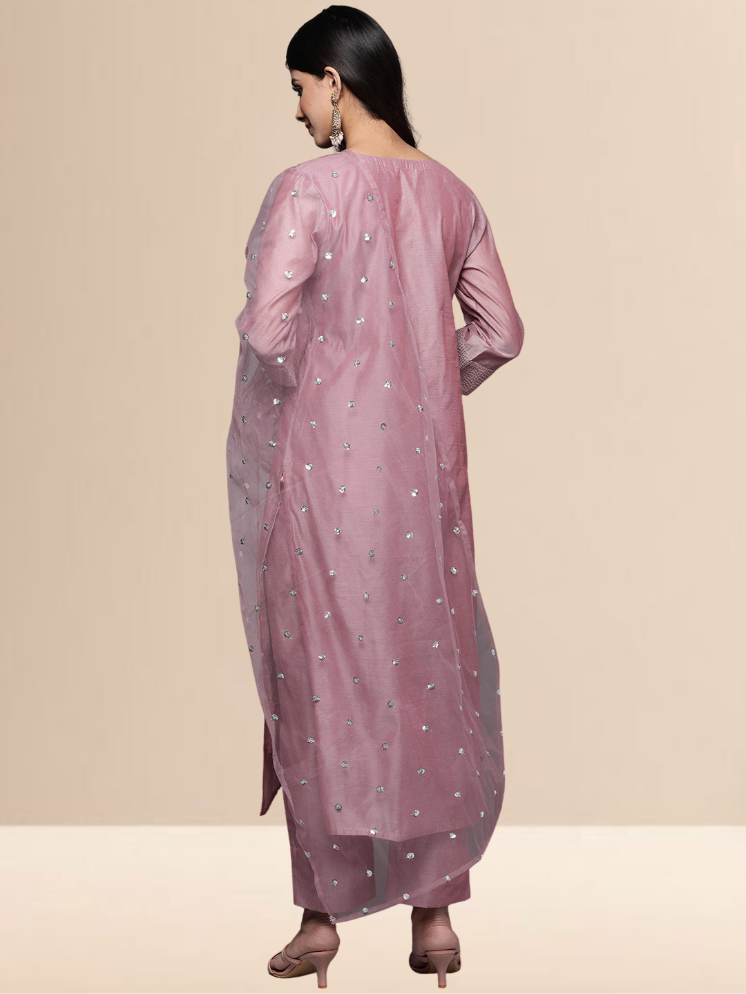 A woman in a mauve cotton-blend kurta set with white thread embroidery on the neck and a sheer sequined dupatta.