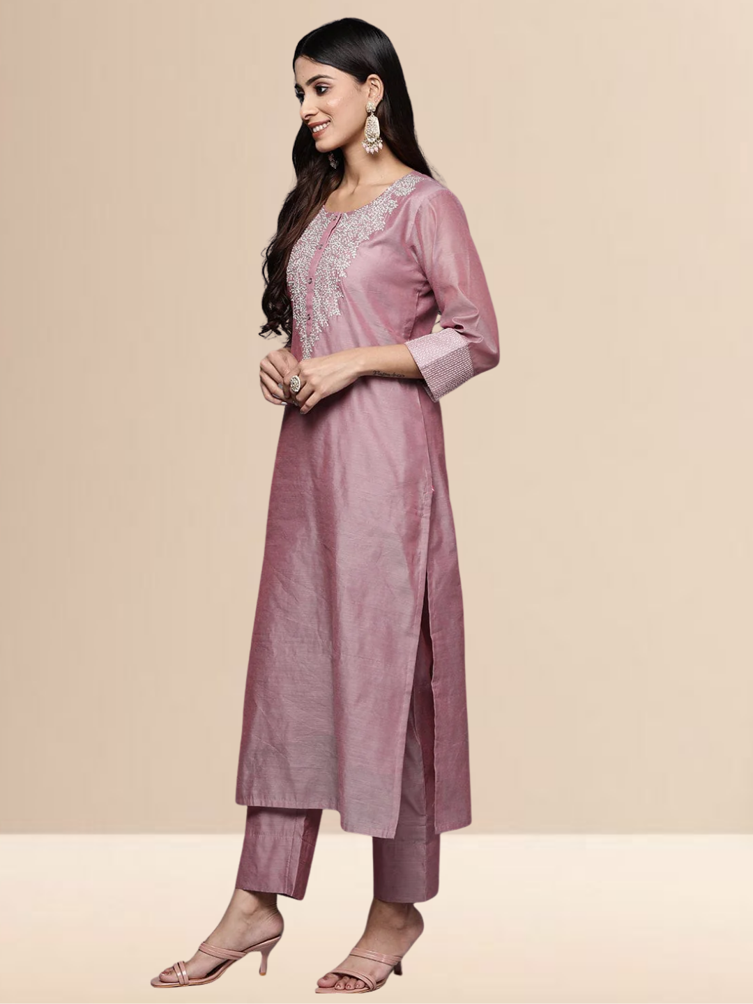 A woman in a mauve cotton-blend kurta set with white thread embroidery on the neck and a sheer sequined dupatta.