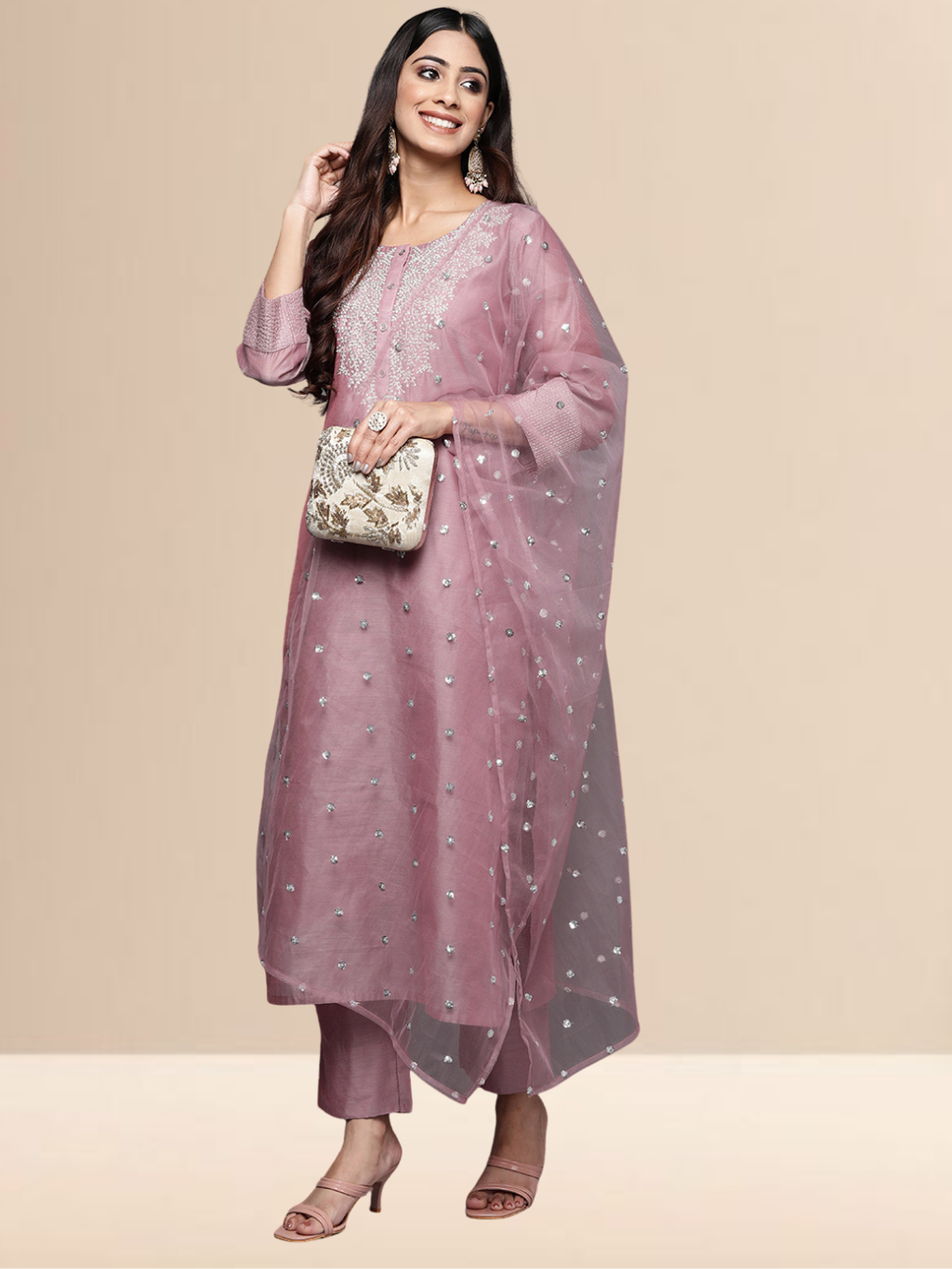 A woman in a mauve cotton-blend kurta set with white thread embroidery on the neck and a sheer sequined dupatta.