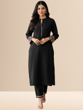Woman wearing a jet black cotton kurta set with pink floral embroidery on the sleeves and matching lace detailing on the neckline and pants.