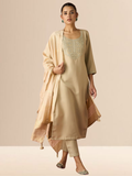 A woman wearing a beige cotton blend kurta set with an embroidered yoke, matching trousers, and a gold-bordered dupatta.