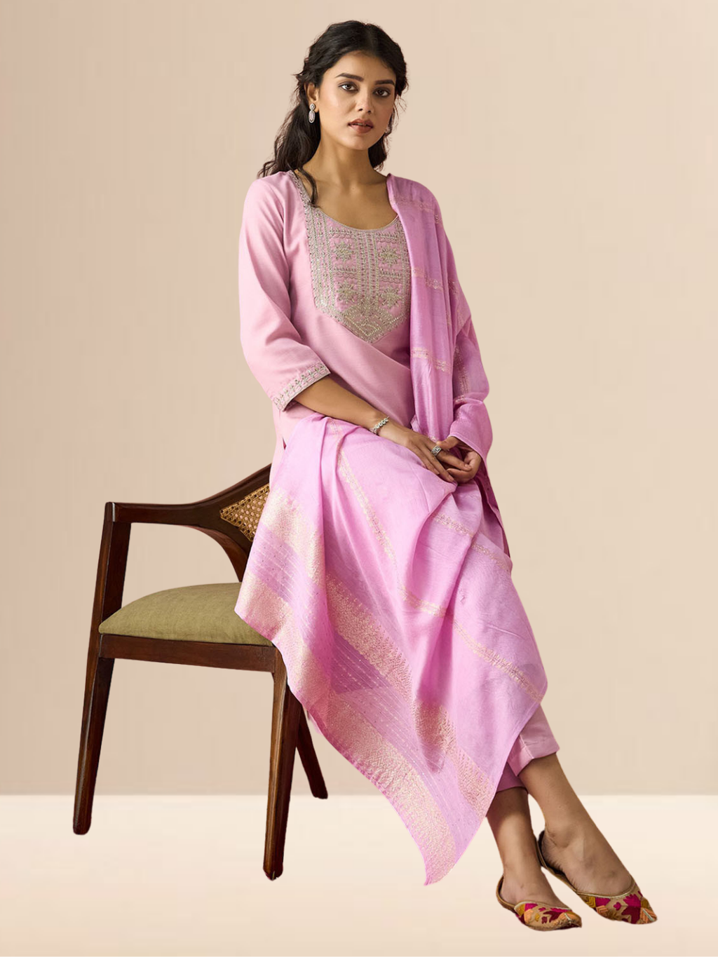 Woman wearing a blush pink cotton blend kurta set with silver embroidery on the neck and a zari-striped dupatta.