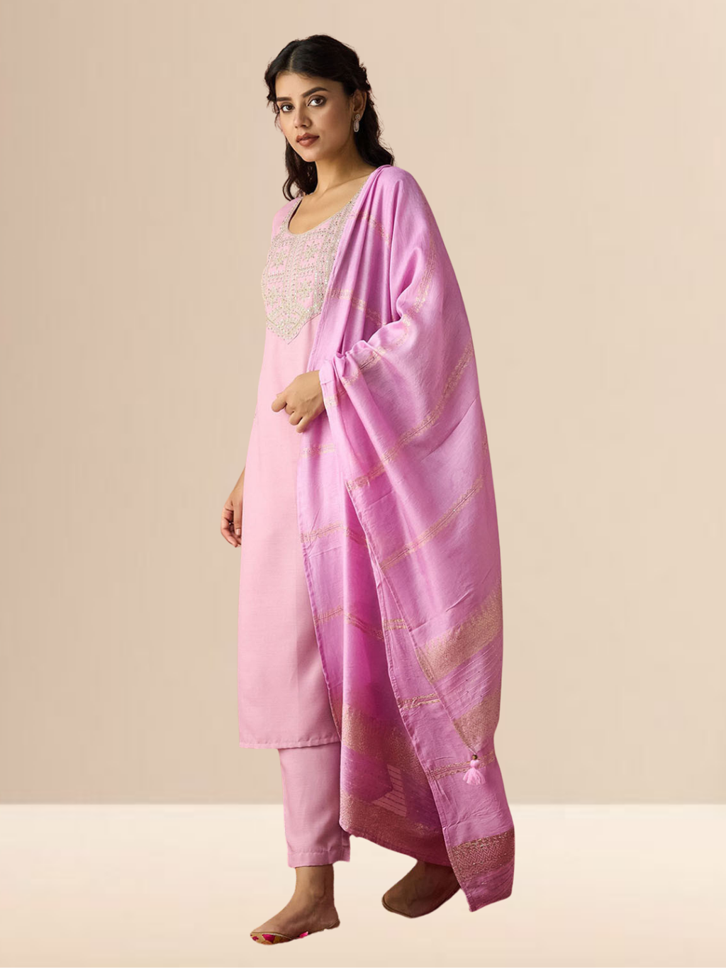 Woman wearing a blush pink cotton blend kurta set with silver embroidery on the neck and a zari-striped dupatta.