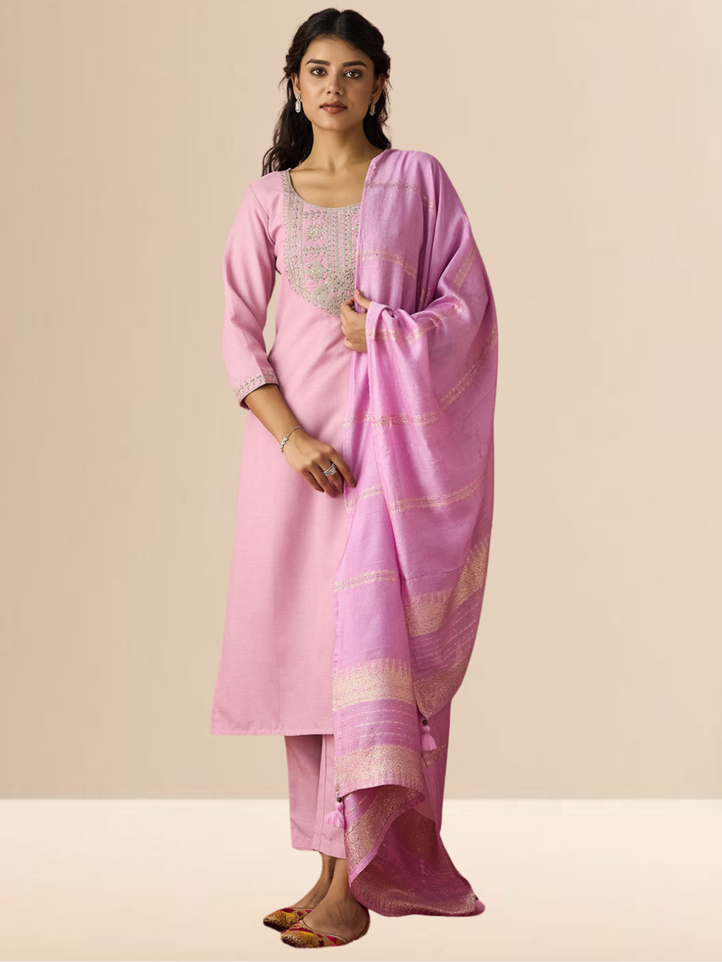 Woman wearing a blush pink cotton blend kurta set with silver embroidery on the neck and a zari-striped dupatta.