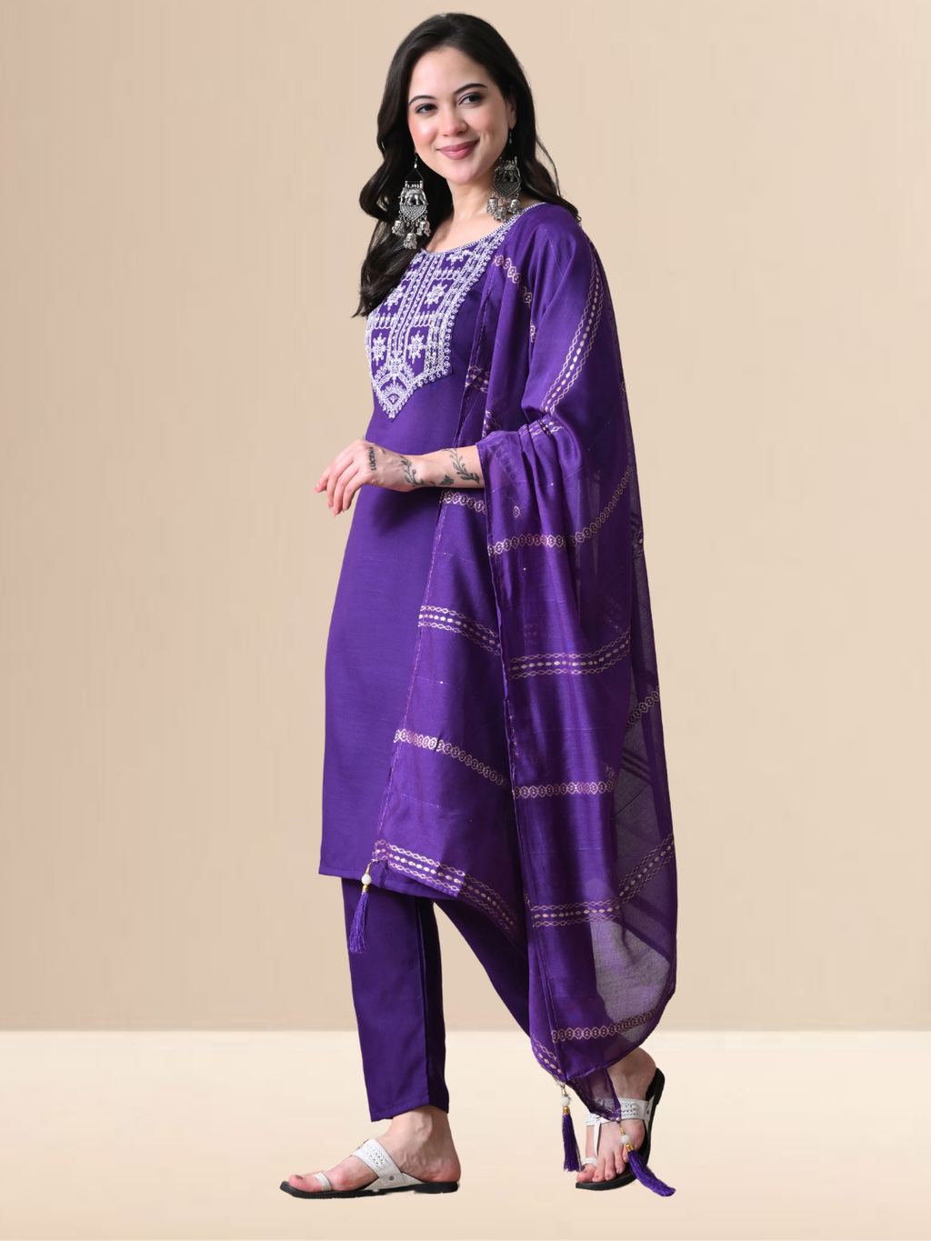 Woman wearing a purple traditional outfit with white embroidery on a beige background