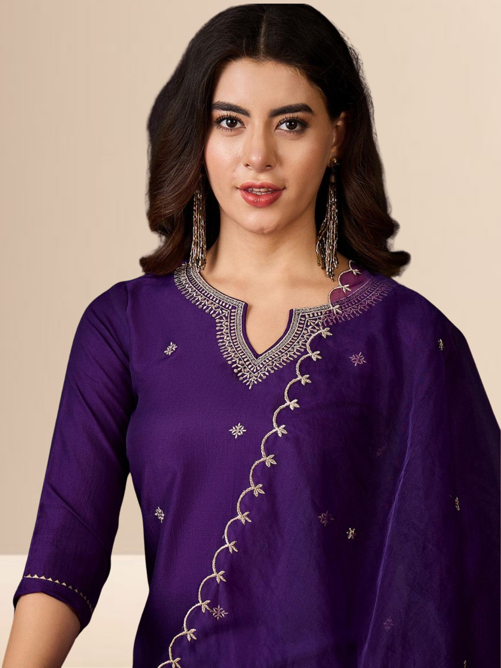 Woman wearing a purple traditional outfit with silver embroidery on a beige background