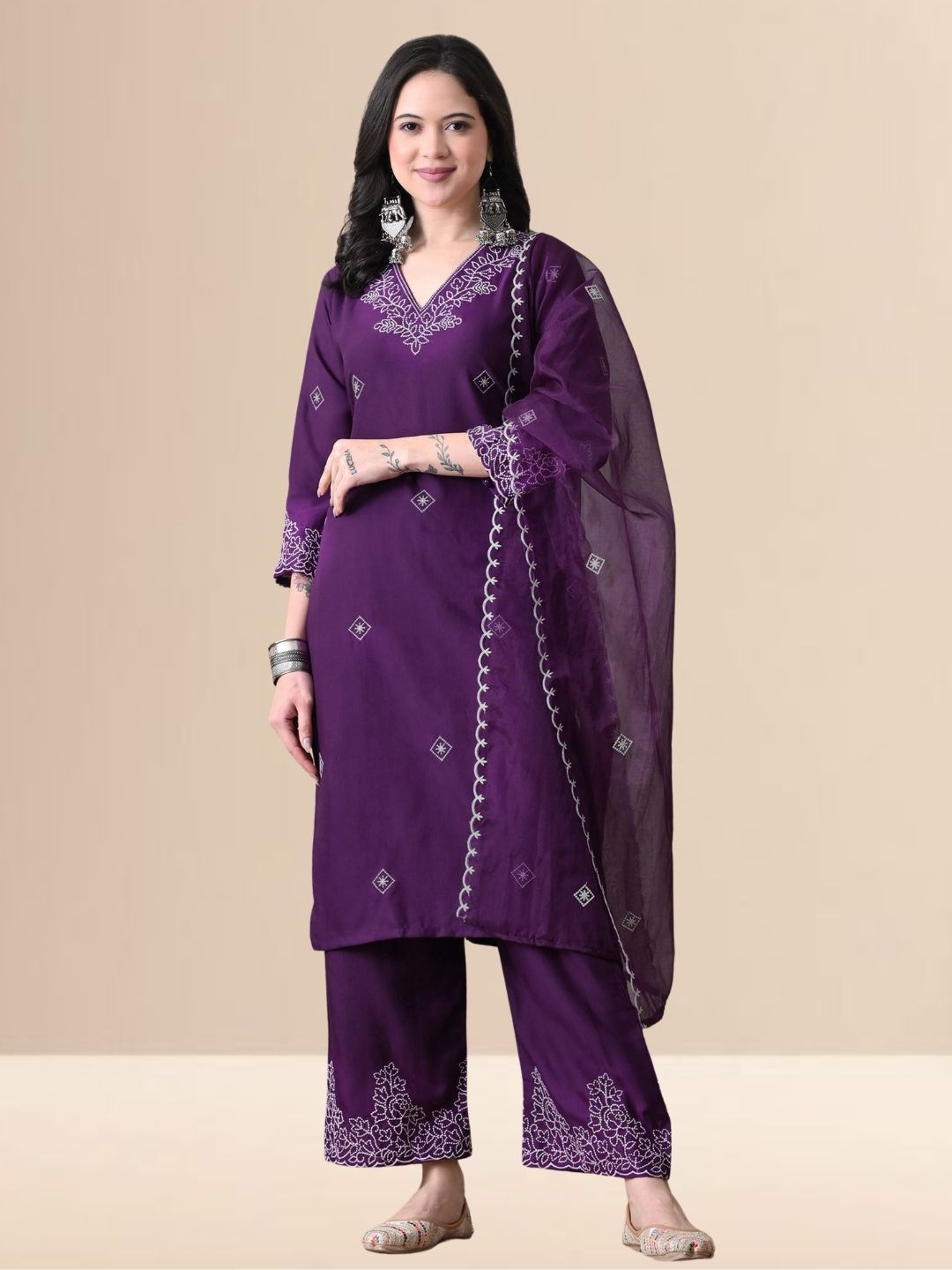 Woman wearing a deep purple cotton blend kurta set with white V-neck embroidery and a sheer scalloped dupatta.