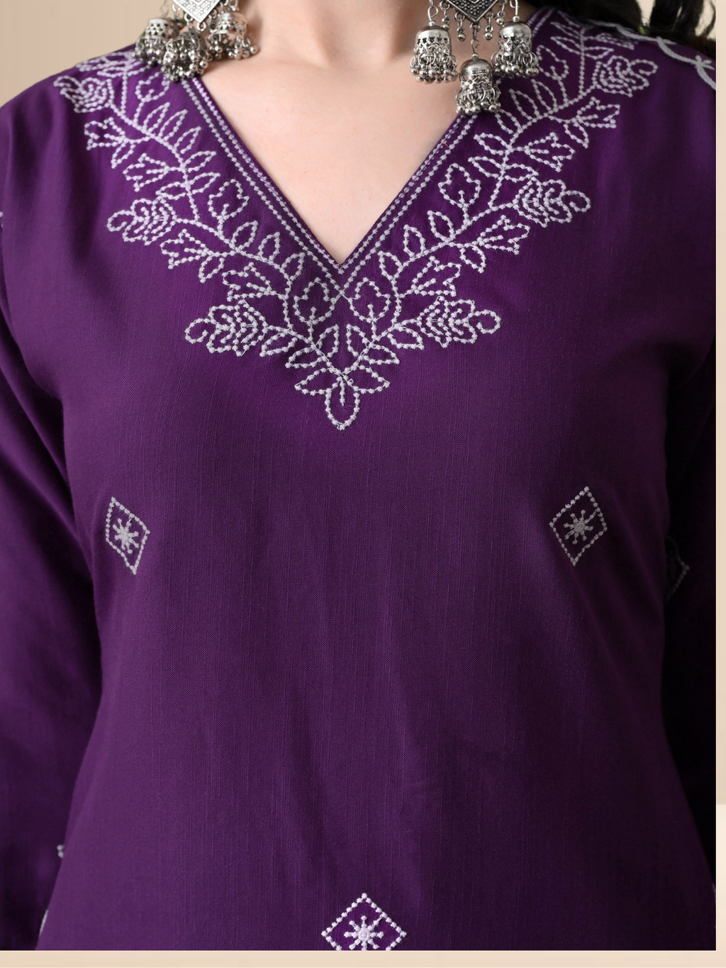 Woman wearing a deep purple cotton blend kurta set with white V-neck embroidery and a sheer scalloped dupatta.