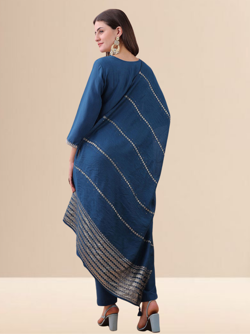 Woman wearing a teal blue cotton blend kurta set with silver embroidery on the neck and a matching striped tasseled dupatta.