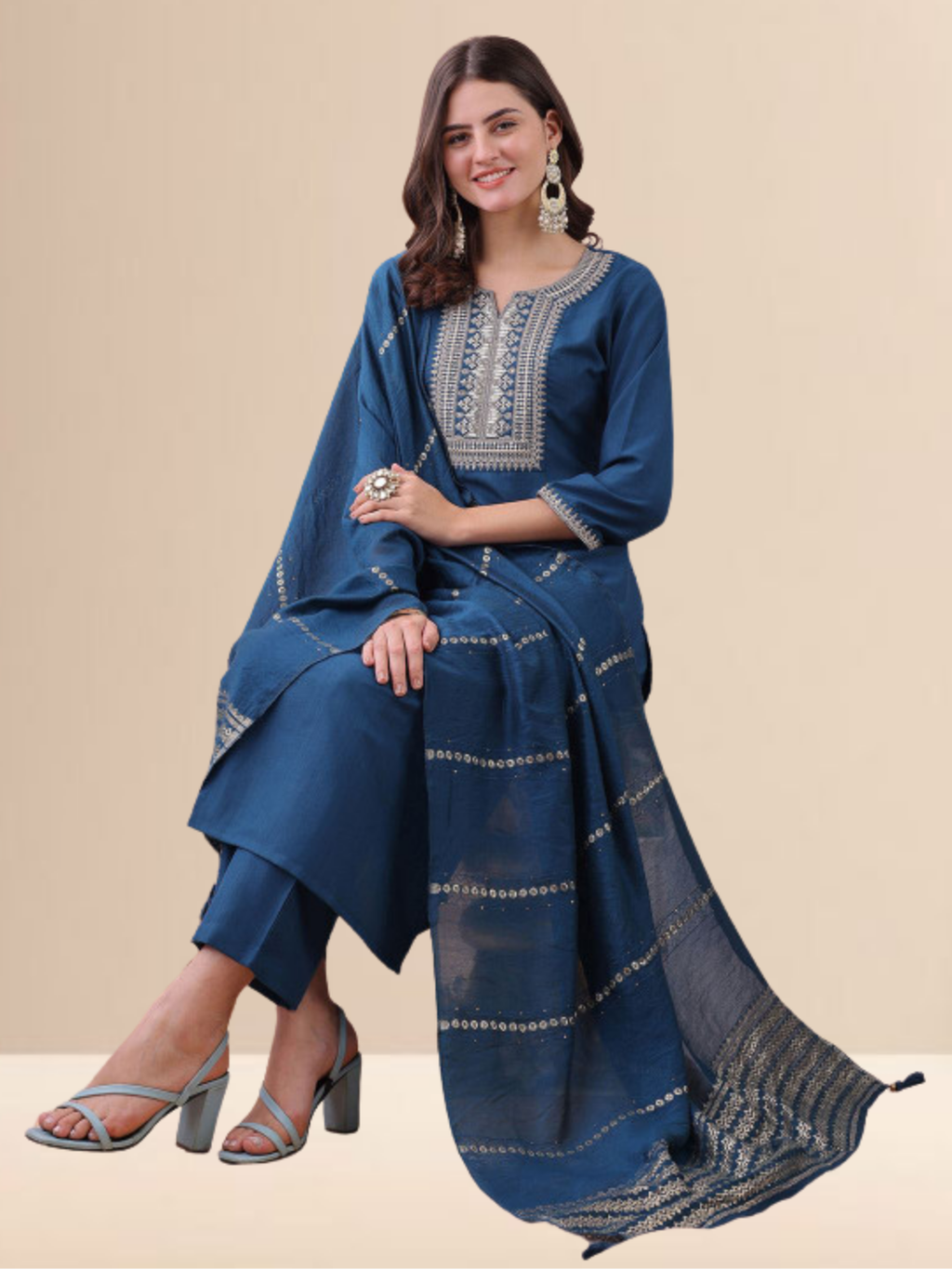 Woman wearing a teal blue cotton blend kurta set with silver embroidery on the neck and a matching striped tasseled dupatta.