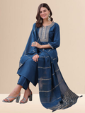 Woman wearing a teal blue cotton blend kurta set with silver embroidery on the neck and a matching striped tasseled dupatta.