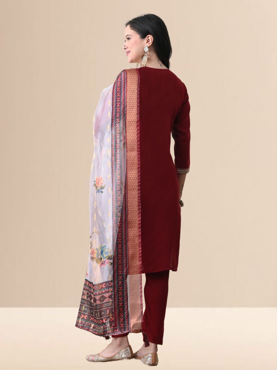 Woman wearing a maroon embroidered cotton kurta set with a floral organza dupatta and matching pants for festive or daily wear.