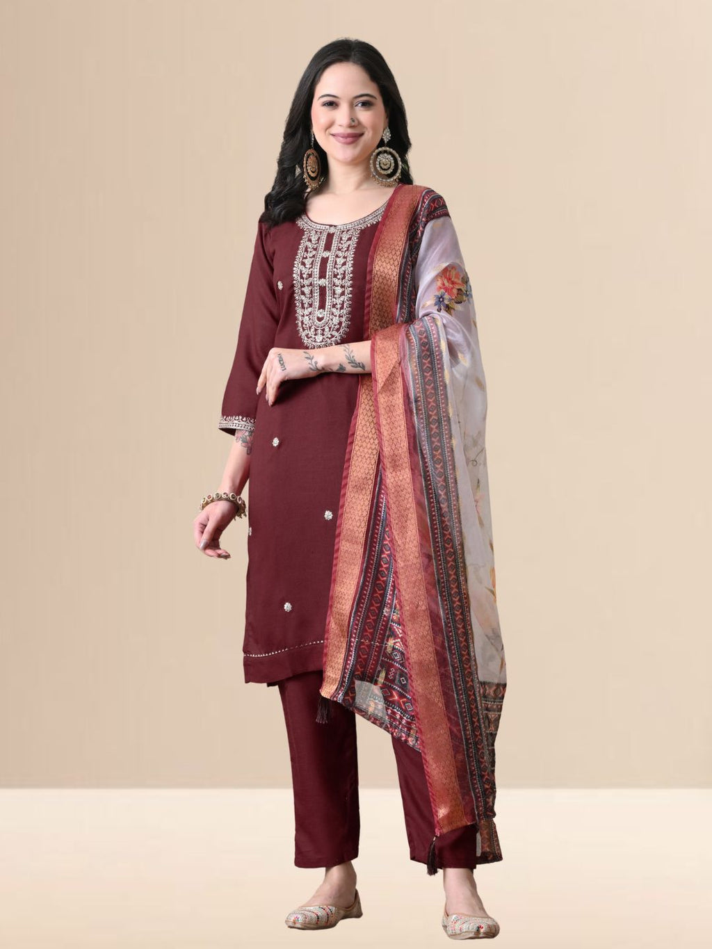 Woman wearing a maroon embroidered cotton kurta set with a floral organza dupatta and matching pants for festive or daily wear.