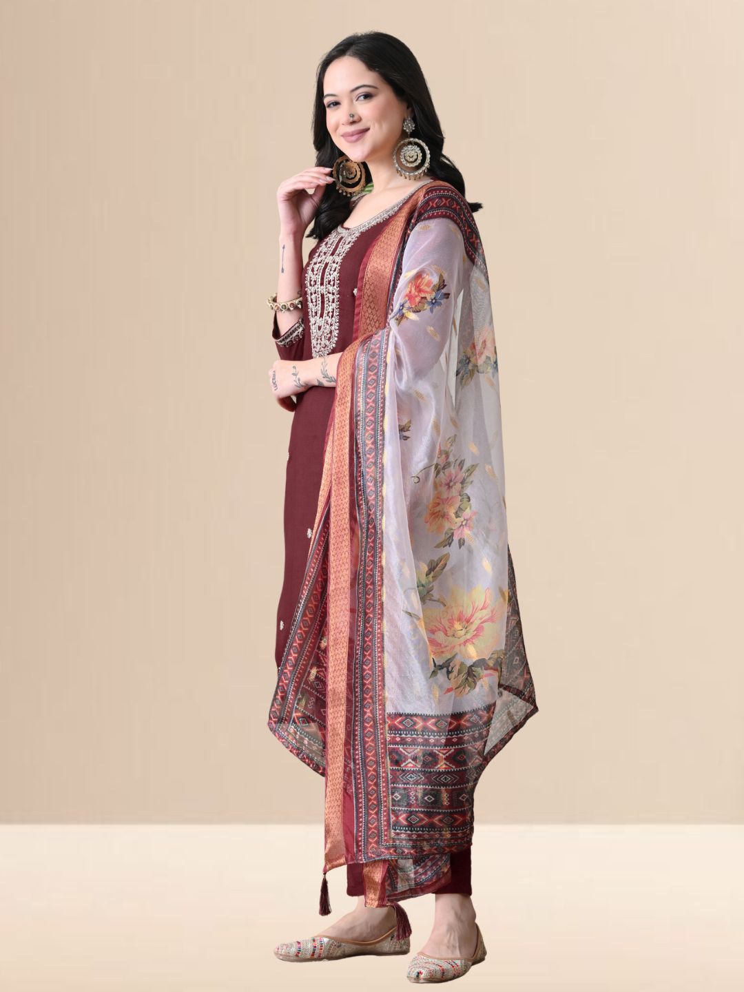 Woman wearing a maroon embroidered cotton kurta set with a floral organza dupatta and matching pants for festive or daily wear.
