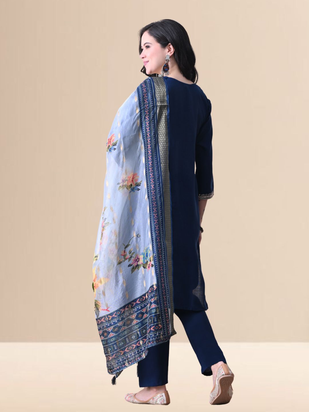 A woman posing in a royal blue embroidered cotton kurta set with matching pants and a light blue floral organza dupatta from The Desi Cloth.