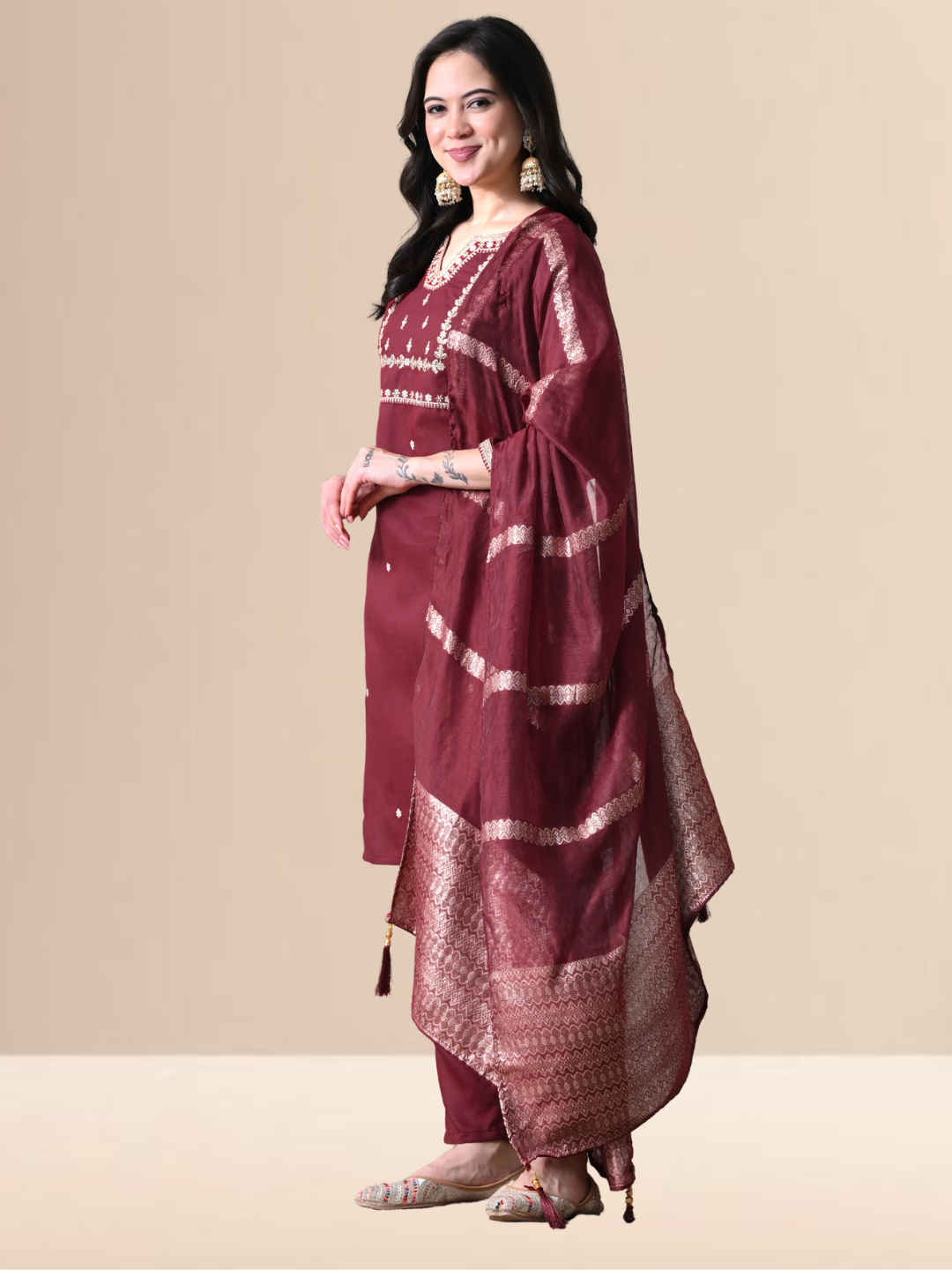 Woman wearing a maroon cotton blend kurta set with intricate silver embroidery on the yoke and a matching striped -style dupatta.
