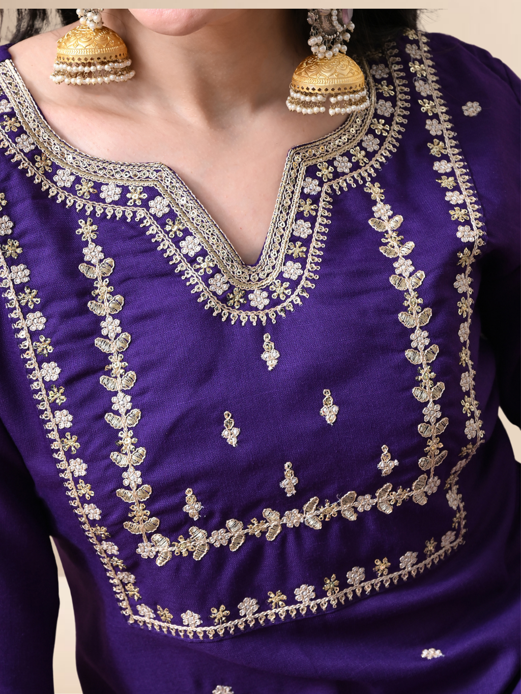 Woman wearing a royal purple cotton blend kurta set with silver embroidery, matching pants, and sheer dupatta.